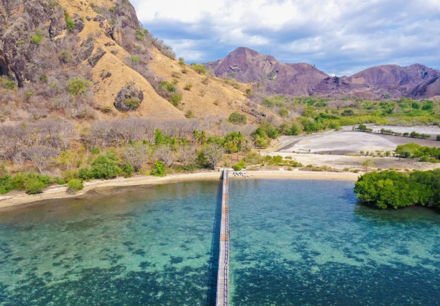 Wooden pier extending into turquoise Indonesian waters